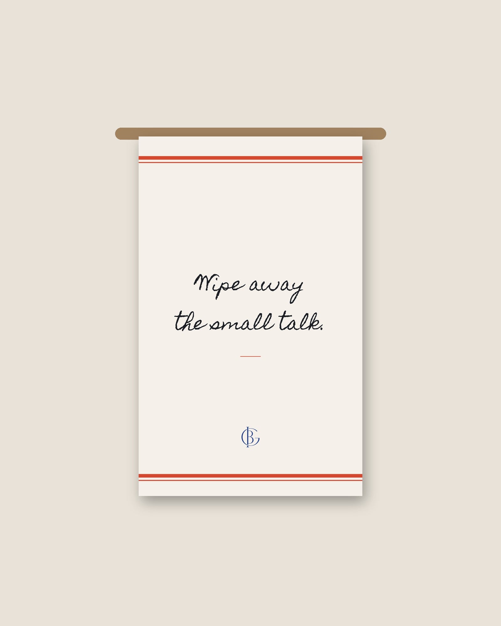 The Small Talk Kitchen Towel hanging from a wooden rail