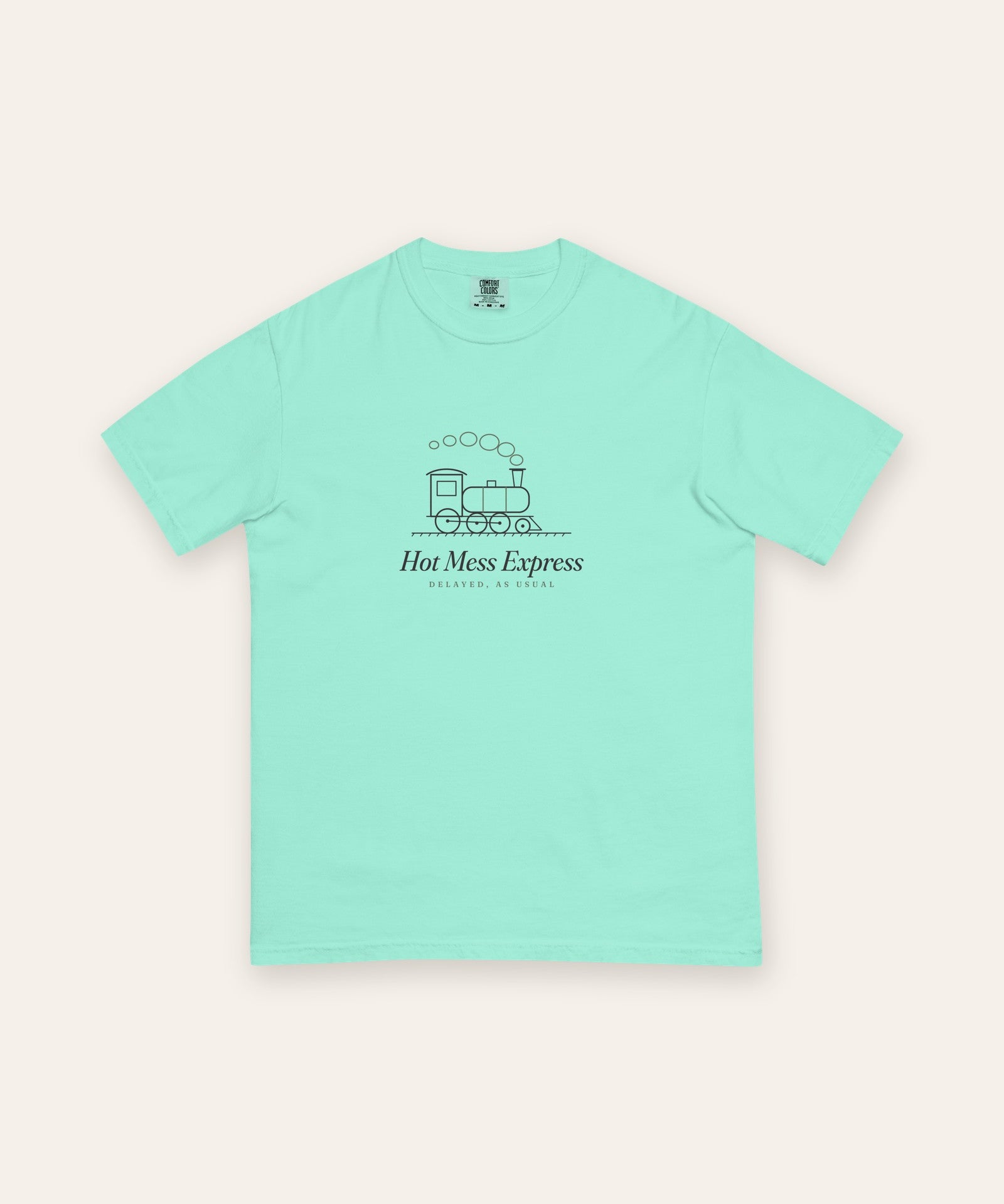 The Hot Mess Express Tee in Chalky Mint, flat lay front, product shot on cream