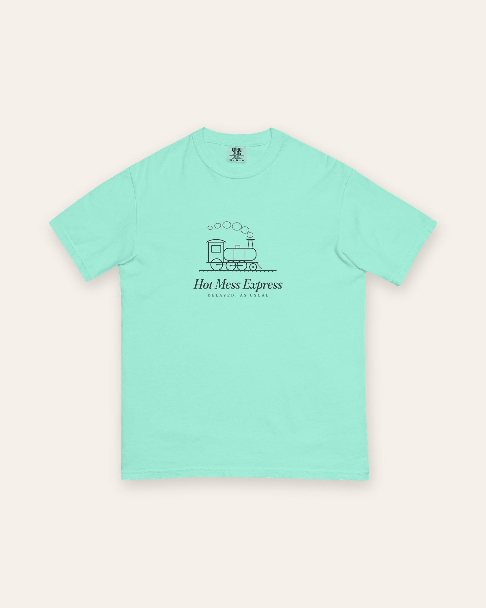 The Hot Mess Express Tee in Chalky Mint, flat lay front, product shot on cream