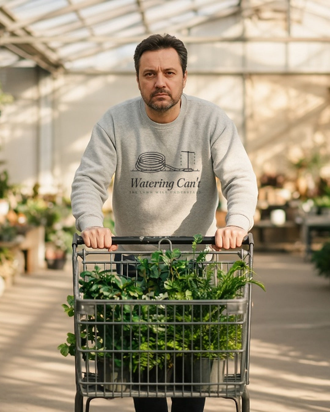 The Watering Can't Crewneck in Ash, a man in Ash pushing a cart full of plastic plants