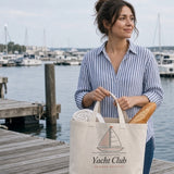 The Yacht Club Tote in Oyster, woman on a marina dock with the tote holding a baguette and a rolled towel