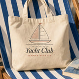 The Yacht Club Tote in Oyster, the tote on a striped deck chair with a paperback and a lemon soda